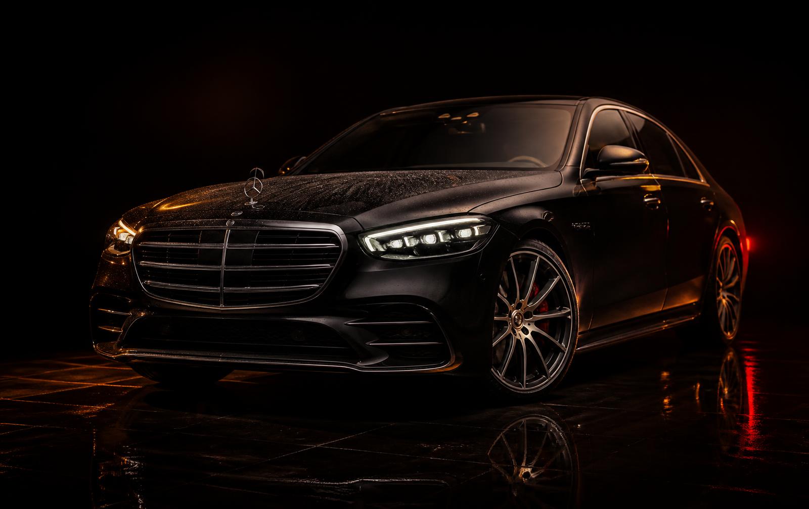 Freshly detailed black luxury sedan with mirror-gloss paint under warm studio light